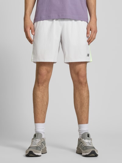 Männermodel trägt Shorts mit elastischem Bund und Logo von New Balance in Weiß mit Regular-Fit, Logo, Tunnelzug, Ganzkörperansicht von vorne.