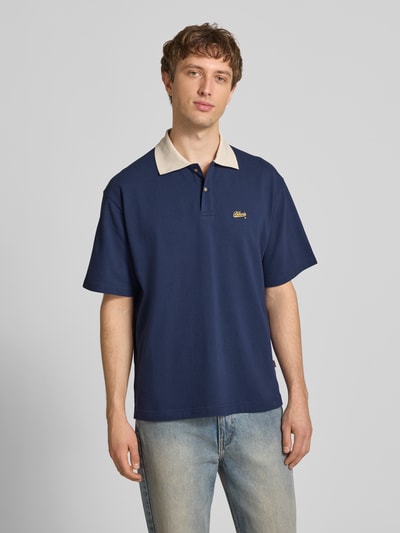 Männermodel trägt Regular Fit Piqué-Poloshirt mit Label-Stitching von BLKVIS aus Baumwoll-Mix mit Knopfleiste, Ganzkörperansicht von vorne. Rückenlänge bei Größe M: 63 cm.