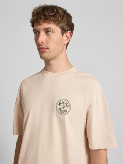 Männermodel trägt Oversized T-Shirt mit Label-Print von Pegador, Beige, Reine Baumwolle, Rundhalsausschnitt, Nahaufnahme Oberkörper.