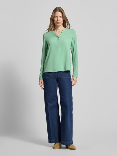 Frauenmodel trägt Regular Fit Bluse aus reiner Viskose mit Tunika-Ausschnitt von Christian Berg Woman in Grün mit Knopfleiste und langärmeligem Design, passend für Damen, Ganzkörperansicht von vorne.