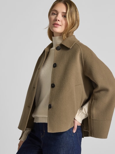 Frauenmodel trägt Relaxed Fit Jacke aus Woll-Mix mit Umlegekragen von Blonde No. 8, beigebraun, sichtbar Knopfleiste, Eingrifftaschen, weiche Textur, kombiniert mit hellem Rollkragenpullover und Jeans, Ganzkörperansicht von vorne. Rückenlänge 61 cm, Schulterbreite 45 cm, Brustweite 47 cm, Ärmellänge 55 cm.