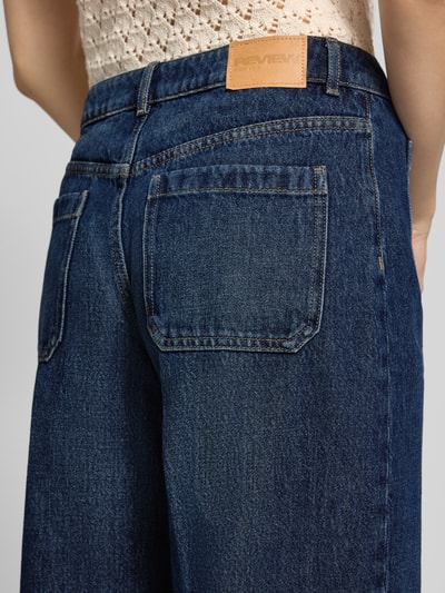 Männermodel trägt Wide Leg Jeans mit aufgesetzten Taschen von Review, granatowy denim, czysta bawełna, detal tylnej kieszeni, zbliżenie tylnej części
