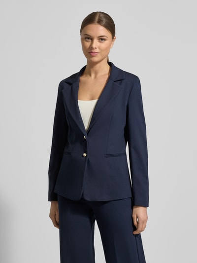 Vrouwenmodel draagt Slim Fit Blazer uit viscosemix model 'Ritmo' van Marella in donkerblauw met reverskraag en paspelzakken, frontale totaalopname.