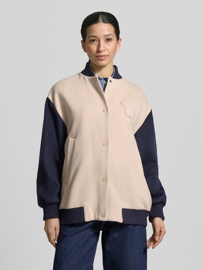 Vrouwenmodel draagt Relaxed Fit College-jack van scheerwolmix Model 'ELLISSE' van Weekend Max Mara, effen, tweekleurige look, comfort fit, collegekraag, drukknoopsluiting, labelstitching, lange mouw, romp/mouwboord geribd, zij-steekzakken, detailopname bovenlichaam.