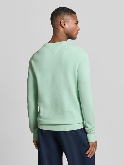 Männermodel trägt Regular Fit Strickpullover aus reiner Baumwolle von Tommy Hilfiger in Optik: Unifarben Strickoptik, Ganzkörperansicht Rückansicht.