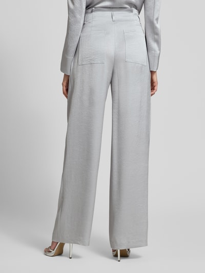 Männermodel trägt Wide Fit Stoffhose mit gelegten Falten von Marc Cain, mieszanka acetatu, wpuszczane kieszenie, z tyłu kieszeń, zapięcie na haftkę i zamek błyskawiczny, szerokość w rozmiarze 36: 38 cm, długość wewnętrzna nogawki w rozmiarze 36: 83 cm, spodnie materiałowe, kolor jasnoszary, gładka tekstura, całkowity widok z tyłu