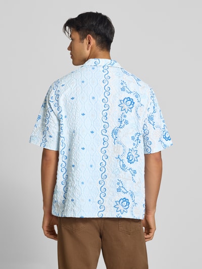 Männermodel trägt Relaxed Fit Freizeithemd aus Seersucker mit Logo-Stitching von adidas Originals, Weiß und Blau mit Muster, Ganzkörperansicht Rückansicht