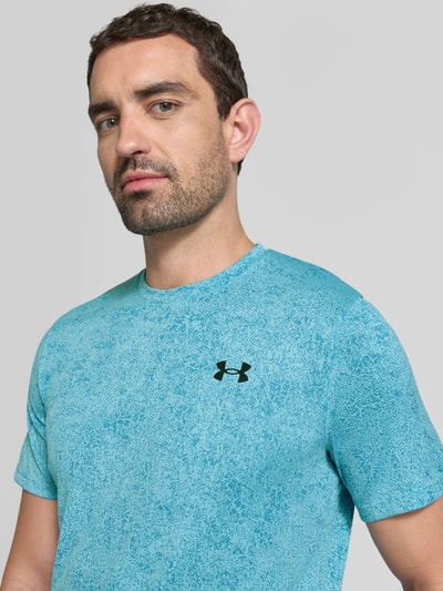 Männermodel trägt Funktionsshirt im all-over look mit Logo Modell 'Pixelate' von Under Armour, regular fit, ronde hals, ruglengte maat M 70 cm, Nahaufnahme Oberkörper.
