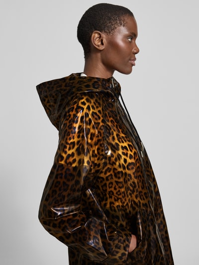 Frauenmodel trägt Regular Fit Regenmantel mit Allover-Logo-Print Modell 'Nilla' von STAND STUDIO aus bawełna, kaptur z tunelem, zamek błyskawiczny dwustronny, wpuszczane kieszenie; długość tyłu w rozmiarze 36: 90 cm, szerokość ramion w rozmiarze 36: 44 cm, szerokość klatki piersiowej w rozmiarze 36: 58 cm, długość rękawów w rozmiarze 36: 61 cm, wzór w odcieniach brązu. Detailaufnahme Oberkörper.