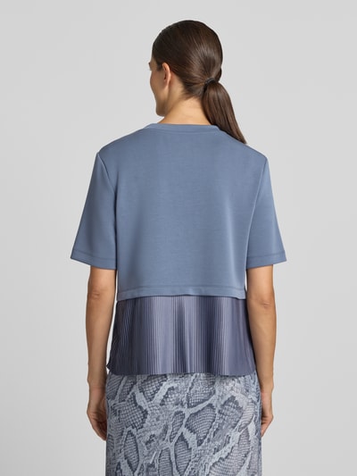 Frauenmodel trägt Sweatshirt mit Rundhalsausschnitt von Marc Cain, elastyczna mieszanka materiałów z dodatkiem wiskozy, prosty krój, okrągły dekolt, rękaw o dł. 1/2, widoczne gładkie i plisowane tekstury, odcienie niebieskiego, Ganzkörperansicht Rückansicht
