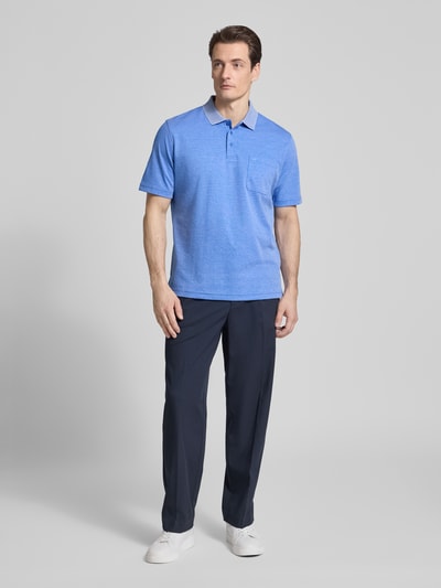 Männermodel trägt Regular Fit Poloshirt mit Brusttasche von Christian Berg Men aus Material-Mix mit Baumwoll-Anteil, Ganzkörperansicht von vorne.