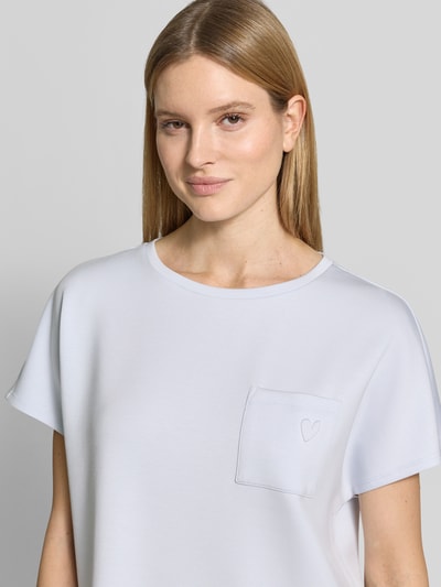Frauenmodel trägt Loose Fit T-Shirt aus Modal-Mix von Tom Tailor, Optik: Unifarben, Motiv-Prägung, Brusttasche, Stretch, Nahaufnahme Oberkörper.