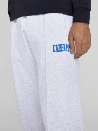 Männermodel trägt Sweatpants mit elastischem Bund und Label-Print von Carhartt Work In Progress, Reine Baumwolle, Nahaufnahme Oberschenkel.