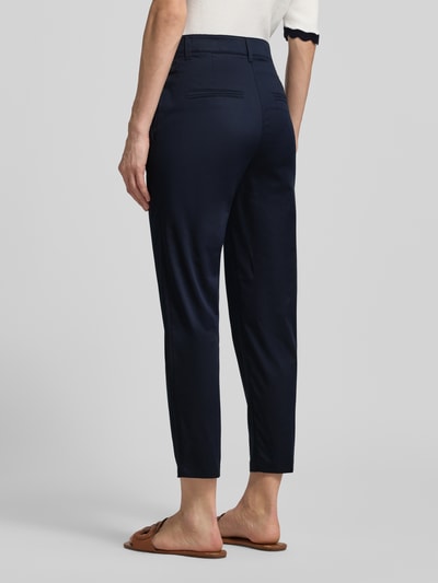 Frauenmodel trägt Hose mit Bügelfalten und Eingrifftaschen von Marc Cain aus Baumwoll-Viskose-Mix in Dunkelblau, Regular-Fit, Label-Detail, Ganzkörperansicht Rückansicht.