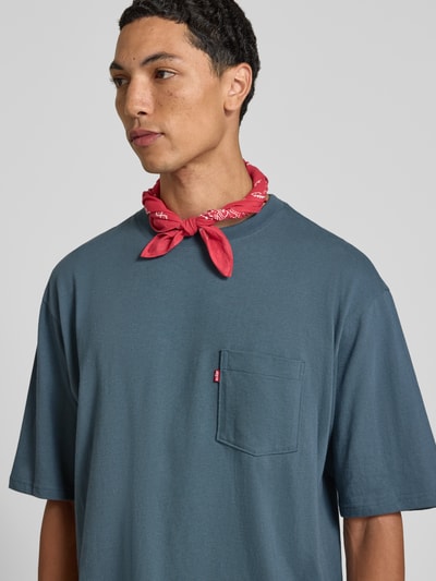 Männermodel trägt Regular Fit T-Shirt aus reiner Baumwolle von Levi's® in Blau mit aufgesetzter Brusttasche, Nahaufnahme Oberkörper.