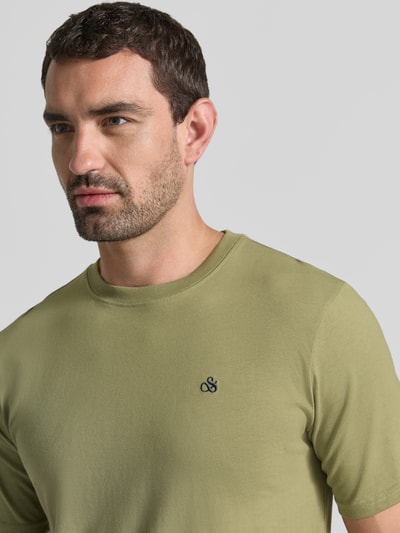 Männermodel trägt T-Shirt mit Label-Stitching und Rundhalsausschnitt von Scotch & Soda aus reiner Baumwolle, Nahaufnahme Oberkörper.