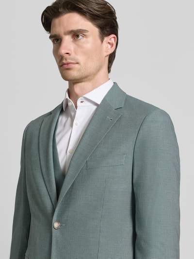 Mannenmodel draagt Regular Fit Blazer met reverskraag van MCNEAL, lichtgroen met twee knopen, borstzakje, patzakken, detailopname bovenlichaam.