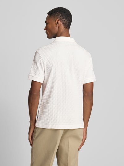 Männermodel trägt Regular Fit Poloshirt mit V-Ausschnitt Modell 'Rauljose' von JOOP! Collection aus reiner Baumwolle mit Strukturmuster, Ganzkörperansicht Rückansicht.