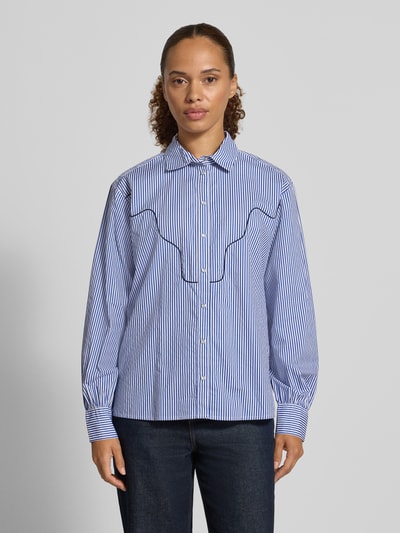Frauenmodel trägt Regular Fit Hemdbluse aus reiner Baumwolle von Christian Berg Woman, blau-weiß gestreift, Ganzkörperansicht von vorne. Hemdblusenkragen, durchgängige Knopfleiste, lange Ärmel, glatte Textur. Rückenlänge 59 cm, Ärmellänge 59 cm bei Größe 36.