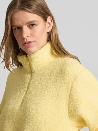 Vrouwenmodel draagt Regular Fit Pullover met opstaande kraag model 'Vera' van JJXX in zacht geel teddybont met ritssluiting, nahaufnahme bovenlichaam.