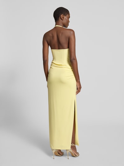 Frauenmodel trägt Neckholder-Maxikleid mit Drapierungen von Forever New in hellgelb, figurbetont, mit Gehschlitz, Ganzkörperansicht Rückansicht.