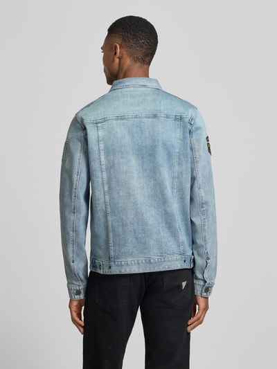 Męski model nosi Jeansjacke mit Label-Patches und Brusttaschen od PME Legend, jasnoniebieski dżins, proste cięcie, z klasycznym kołnierzem, guzikami, aplikacjami oraz kieszeniami; mieszanka bawełny ze stretchem, długość tyłu w rozmiarze M: 65 cm, szerokość ramion w rozmiarze M: 44 cm, szerokość w rozmiarze M: 53 cm, długość rękawa w rozmiarze M: 67 cm, widok sylwetki od tyłu