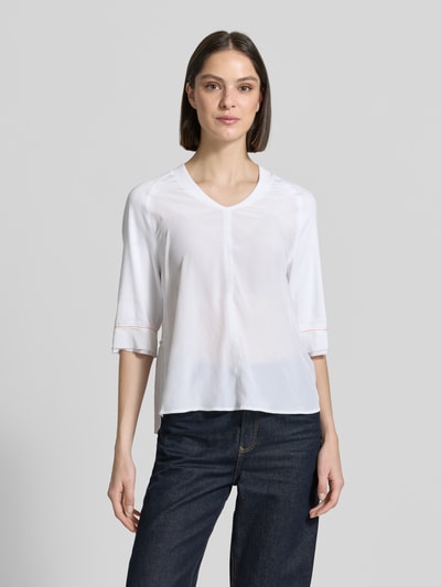 Frauenmodel trägt T-Shirt mit V-Ausschnitt und 3/4-Arm von Marc Cain aus Baumwoll-Elasthan-Mix, Relaxed-Fit, Rückenlänge 60 cm, Ganzkörperansicht von vorne.