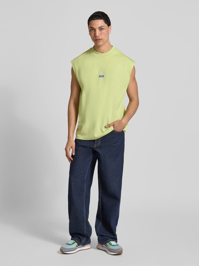 Männermodel trägt Relaxed Fit Tank Top aus reiner Baumwolle Modell 'NAVERTZ' von HUGO Blue, unifarben, Jersey, Label Patch, Ganzkörperansicht von vorne.