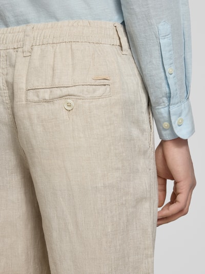 Männermodel trägt Leinenhose mit elastischem Bund Modell 'KARL LAWRENCE' von Jack & Jones, naturfarben, Leinen, Regular-Fit, Detailaufnahme der Rückansicht. Bundweite bei Größe M: 40 cm, Innenbeinlänge bei Größe M: 75 cm.