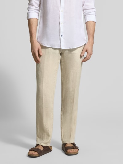 Mężczyzna nosi Straight Fit Leinenhose aus reinen Leinen Modell 'Lynx' od MMX, beżowy kolor, czysta faktura lnu, Szerokość w rozmiarze 32/32: 43 cm, długość nogawki: 81 cm, kieszenie z tyłu, zapięcie na guzik i zamek, Ganzkörperansicht von przodu.