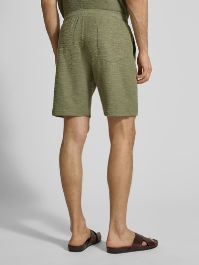 Männermodel trägt Shorts mit elastischem Bund von MCNEAL in Grün mit Strukturmuster, Material-Mix, Regular-Fit, Ganzkörperansicht Rückansicht.