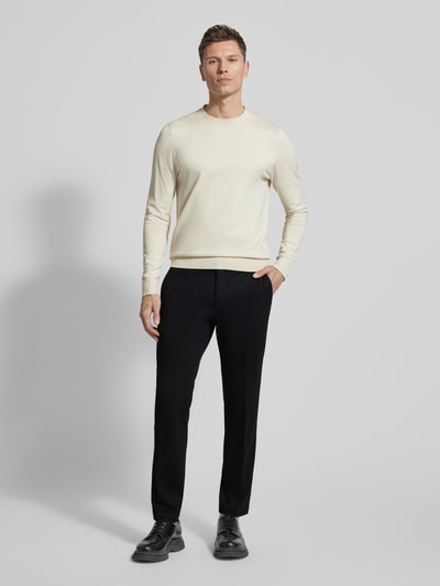 Męski model nosi Straight Fit Stoffhose aus Viskose-Mix von Roy Robson, elastyczna mieszanka wiskozy, kanty, kieszenie z tyłu, zapięcie na guzik i zamek błyskawiczny, szerokość w rozmiarze 50: 44 cm, długość wewnętrzna nogawki w rozmiarze 50: 82 cm, klasyczne kolory, gładkie faktury, spodnie materiałowe, krój straight fit, ganzkörperansicht von vorne.
