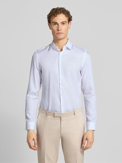 Männermodel trägt Slim Fit Business-Hemd mit Kentkragen von Jake*s in Weiß, reine Baumwolle, glatte Textur, Ganzkörperansicht von vorne.
