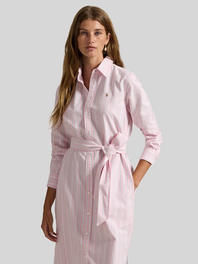 Frauenmodel trägt Regular Fit Oxford-Hemdblusenkleid mit Gürtel von Polo Ralph Lauren aus reiner Baumwolle, rosa-weiß gestreift, seitliche Eingrifftaschen, Logo-Stitching, Knopfleiste, Gürtel, hochgeschlossen, langarm, Nahaufnahme Oberkörper.