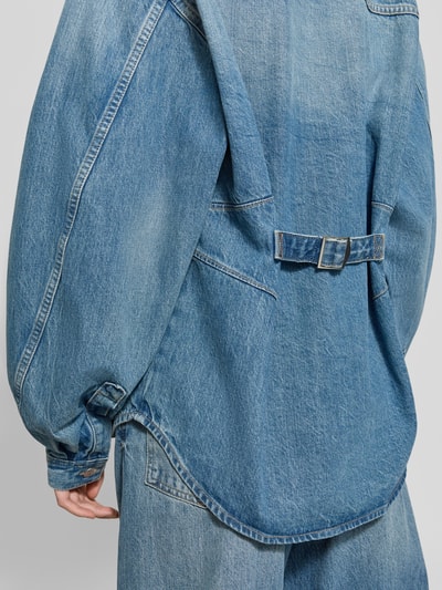 Frauenmodel trägt Oversized Hemdbluse aus reiner Baumwolle Modell 'Sahar' von Samsøe Samsøe in Denim-Optik, Rückansicht, Nahaufnahme Oberkörper.