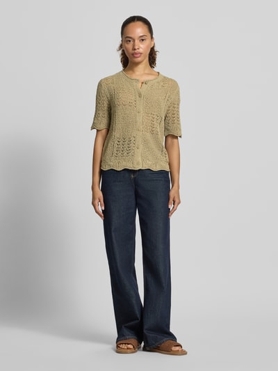 Frauenmodel trägt Regular Fit Strickjacke aus Baumwoll-Mix von Tom Tailor in Beige mit Lochstrickmuster und kurzen Ärmeln, Ganzkörperansicht von vorne.