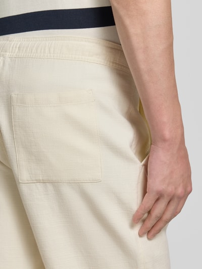 Mężczyzna nosi Shorts aus Baumwolle mit elastischem Bund od JAKE*S STUDIO MEN, jasny beż, tekstura bawełny, krój regular fit, Szerokość w rozmiarze M 47 cm, długość nogawki 26 cm, z tyłu kieszeń, detal tylnej części, zbliżenie na biodro