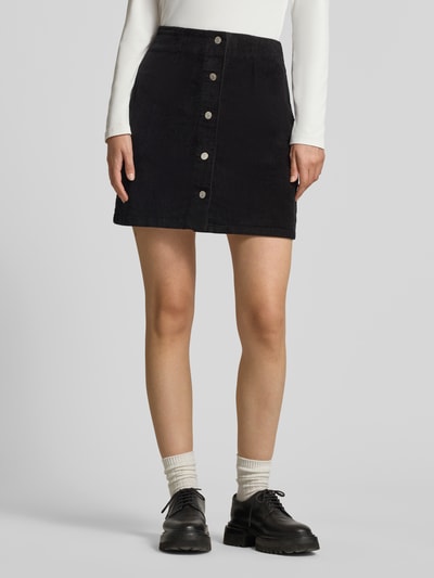 Kobiece modelka nosi czarną spódnicę mini z mieszanki bawełny, model 'ETTA' od VERO MODA, jednolita faktura, widok z przodu, Ganzkörperansicht von vorne.
