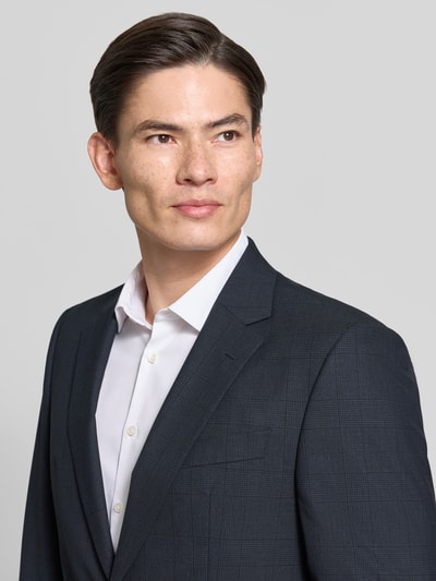 Männermodel trägt Regular Fit Sakko mit Woll-Anteil Modell 'Jasper' von BOSS, dunkelblau mit feinem Karomuster, Nahaufnahme Oberkörper.