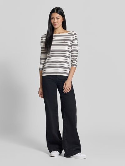 Frauenmodel trägt Slim Fit T-Shirt aus reiner Baumwolle von Tommy Hilfiger, weiß mit schwarzen und beigen Streifen, Ganzkörperansicht von vorne, Damen T-Shirt von Tommy Hilfiger.