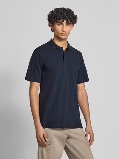 Mannenmodel draagt Regular Fit Poloshirt uit puur katoen model 'Core' van G-Star Raw, heren poloshirt met polokraag en labeldetail, ruglengte bij maat M 72 cm, donkerblauw, vlakke textuur, voorkant volledig zichtbaar, geheelopname van voren.