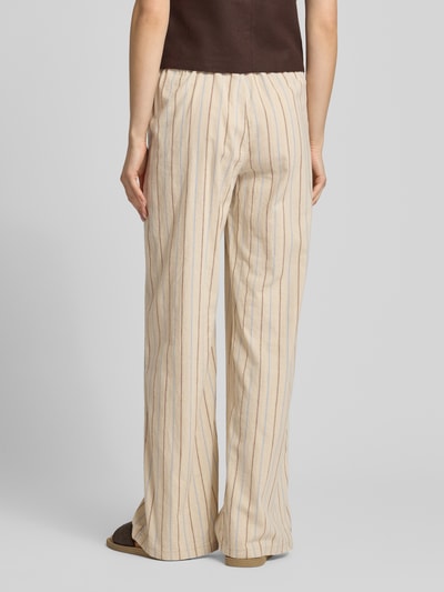 Frauenmodel trägt Wide Leg Pants mit elastischem Bund Modell 'ELLA' von JJXX in Beige mit feinen Streifen, lockerer Baumwoll-Leinen-Mix, Ganzkörperansicht Rückansicht.