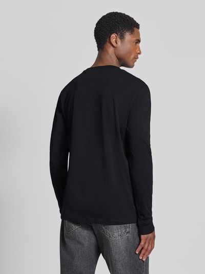 Męski model nosi czarny t-shirt Regular Fit T-Shirt aus reiner Baumwolle Modell 'solid' von Tom Tailor Denim, całopostaciowy widok z tyłu