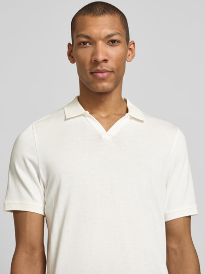 Mężczyznamodel nosi Slim Fit Poloshirt mit Logo-Detail Modell 'Boll' von CINQUE, czysta bawełna, krój slim fit, jasny kolor, krótki rękaw, elastyczne ściągacze, polówkowy kołnierzyk, widoczne logo, długość tyłu w rozmiarze M: 66 cm, zbliżenie na górną część ciała z przodu.