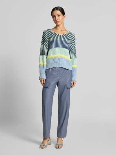 Frauenmodel trägt Oversized Strickpullover mit V-Ausschnitt von Marc Cain, Baumwoll-Mix in Blau, Grün und Gelb, Ganzkörperansicht von vorne.