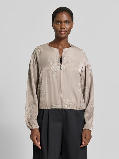 Frauenmodel trägt Blouson aus Viskose-Mix mit Motiv-Stitching Modell 'Ta44mika' von ZABAIONE, beige mit Zierperlen, Ganzkörperansicht von vorne.