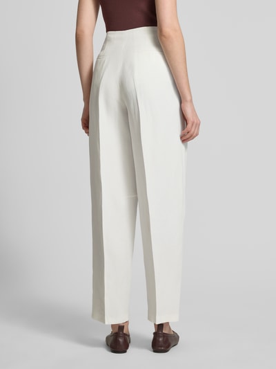 Vrouwenmodel draagt Barrel Hose aus Leinen-Mix Modell 'LINEN/VIS BARREL PANT' van Tommy Hilfiger, beige uni, barrel fit, persvouwen, steekzakken, achter paspelzakken, logodetail, lichte linnenmix textuur, volledig beeld van achteren.