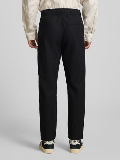 Männermodel trägt Tapered Leinenhose aus Baumwoll-Leinen-Mix Modell 'LINUS' von Only & Sons, Melange-Optik, Ganzkörperansicht Rückansicht.
