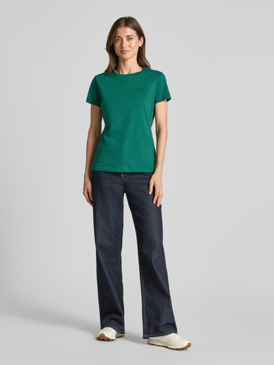 Frauenmodel trägt Regular Fit T-Shirt aus reiner Baumwolle Modell 'ESOGO' von BOSS Orange, Optik: Unifarben, Label-Schriftzug, Rundhals, Kurzarm, Ganzkörperansicht von vorne.
