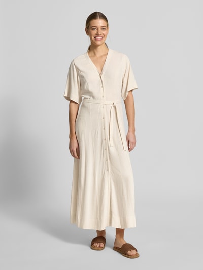 Modelka kobieca ma na sobie Regular Fit Leinenkleid mit V-Ausschnitt Modell 'VIVA' od Selected Femme, jasny, jednolity, z paskiem, materiał wiskozowo-lniany, maxi, bez rękawów, kieszenie boczne, widok całej sylwetki z przodu.